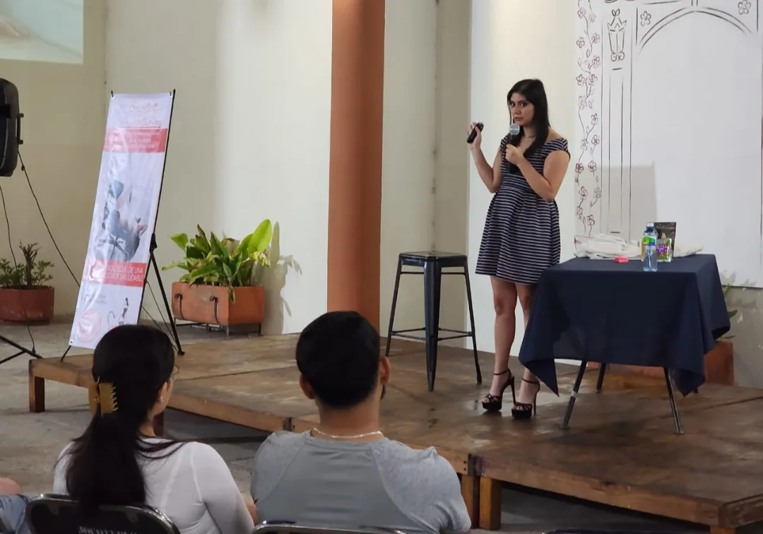 Victoria Hernández explicando frente a asistentes durante una charla presencial