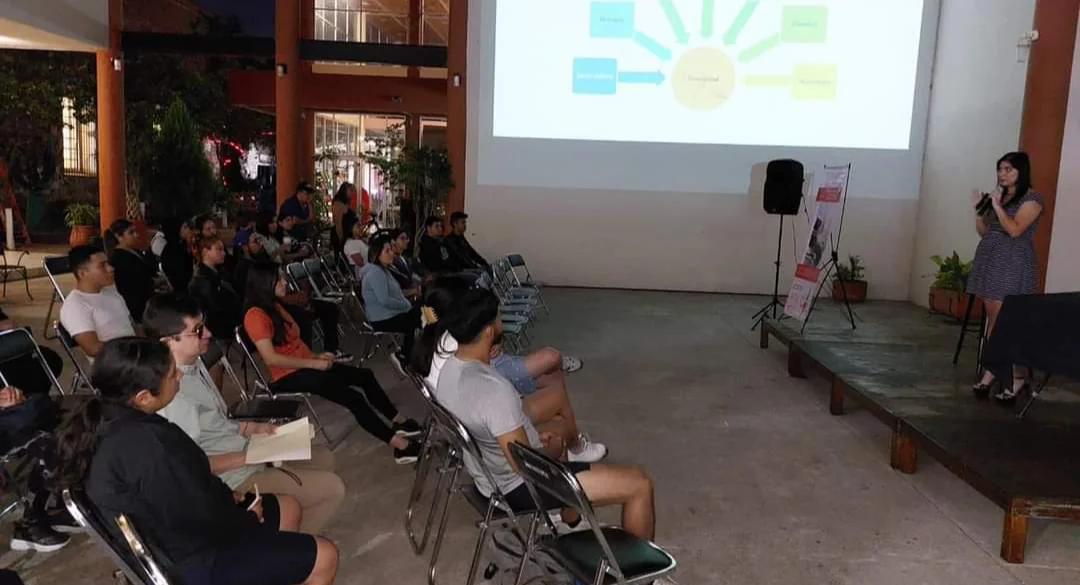Victoria Hernández impartiendo una charla educativa ante un grupo de asistentes